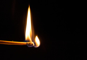 Burning match with a black background.