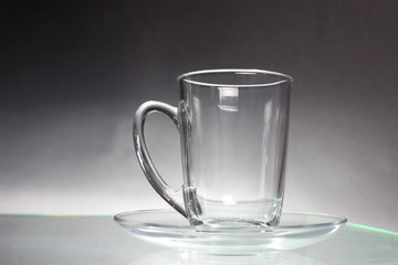 Empty transparent glass cup and saucer