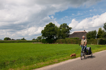 Elderly man at the bike with dog