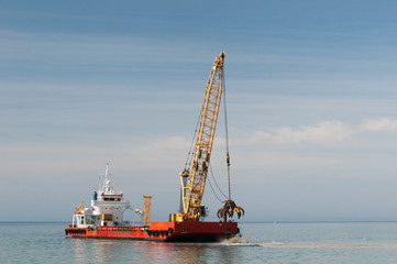 Fototapeta premium Dredger lifts Mud from Harbor