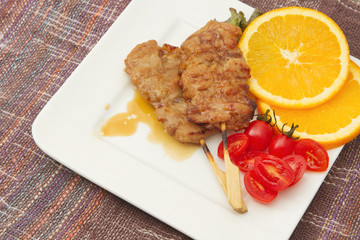 roast pork on a plate with red tomato