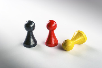 Standing black and red and lying yellow Ludo figure
