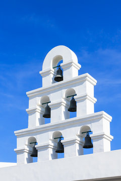 White bell tower santorini style with clear blue sky
