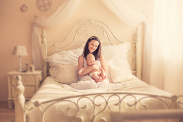 Obraz na płótnie Canvas A mother with a newborn baby on the bed