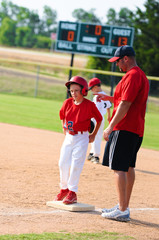 Baseball player and baseball coach at first base.