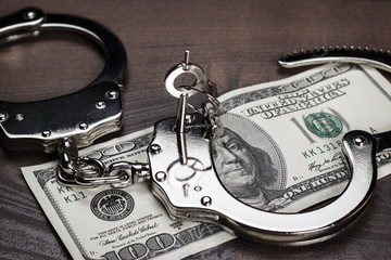 handcuffs and one hundred dollars on the table