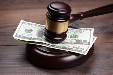 judge gavel and money on brown wooden table