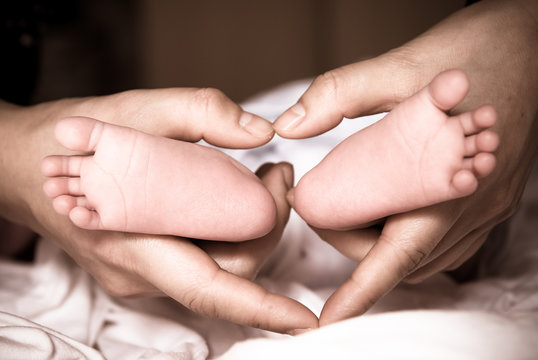 newborn baby feet on female hands