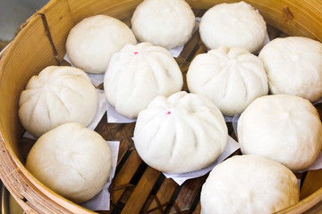 Chinese dumplings being steamed on the traditional bamboo pan