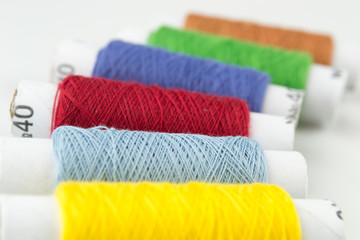 Many-coloured bobbins of thread closeup