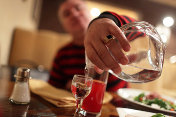 Man pouring vodka in bar