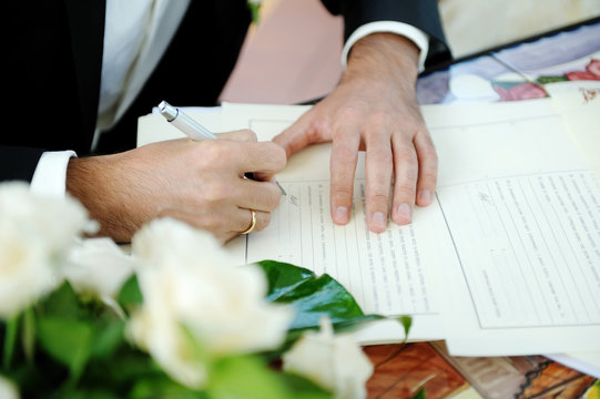Groom signing wedding contract