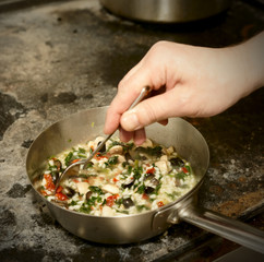Chef is stirring risotto, toned