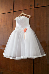 Fototapeta na wymiar White wedding dress with orange bud on hanger