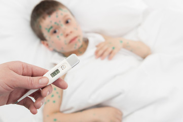 Obraz na płótnie Canvas pomiar temperatury Chłopiec chory w łóżku