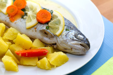 Trout fish with lemon slices and boiled potatoes