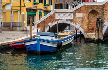 Fototapeta na wymiar Parked boats in front of a bridge in Venice