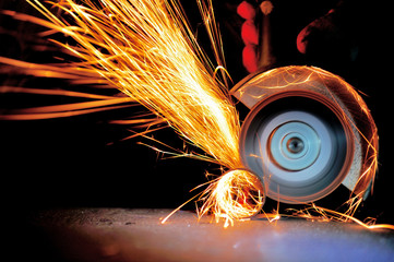 Worker cutting metal with grinder