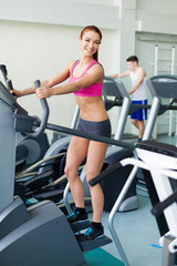 Fototapeta na wymiar fitness model exercising on a cardio machine in fitness center