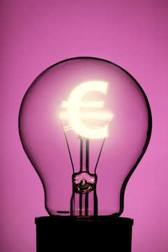 Light bulb with glowing Euro symbol on pink