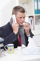 Mann mit Erk&auml;ltung im B&uuml;ro