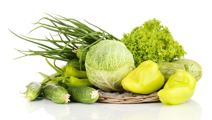 fresh green vegetables on wicker mat isolated on white