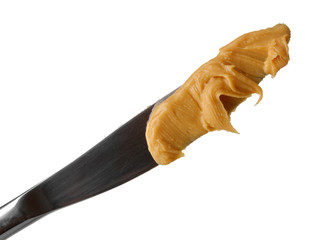 Delicious peanut butter on knife isolated on white close-up