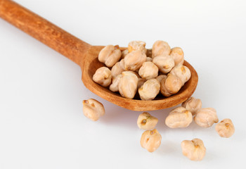 White chickpeas over wooden spoon isolated on white