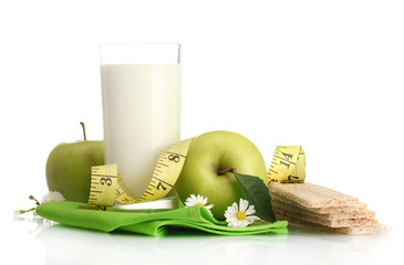 Glass of kefir, green apples, crispbreads and measuring tape