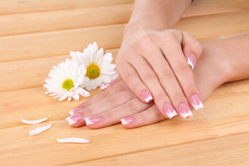Obraz na płótnie Canvas Woman hands with french manicure and flowers