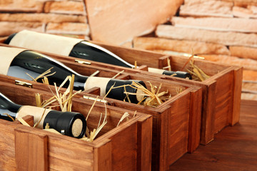 Bottles of old red wine in gift wooden box, on stone background