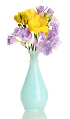Beautiful bouquet of freesias in vase, isolated on white