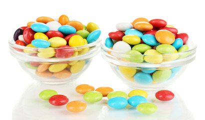 Colorful candies in glass bowls isolated on white