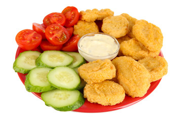 Fried chicken nuggets with vegetables and sauce isolated