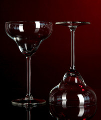 Two glasses on dark red background