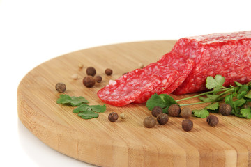Tasty salami on wooden board isolated on white