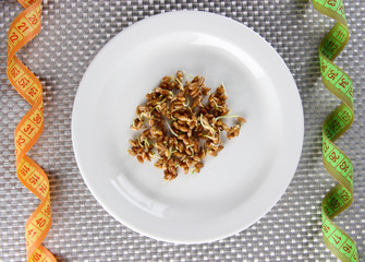 Wheat germs on plate and measuring tape, close up