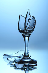 Broken wineglass on blue background