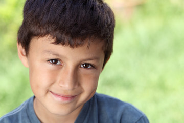 Smiling young boy outside with copy space to right