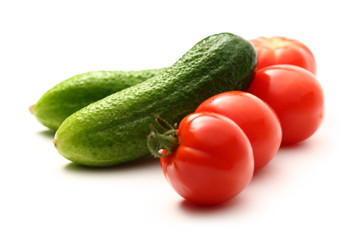 Fresh cucumbers and tomatoes on white