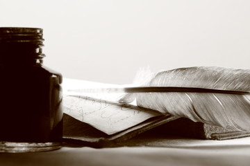Old book with feather and inkpot