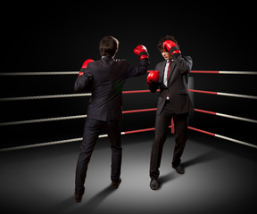 Two young businessman boxing