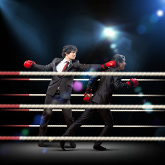 Two young businessman boxing