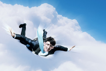 Young businessman flying with parachute on back