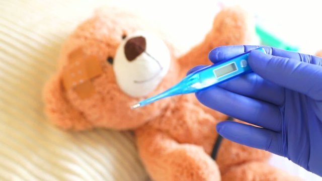 Teddy at the pediatrician with clinical thermometer
