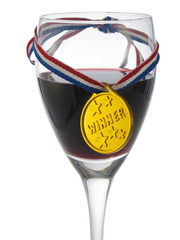 Glass with red wine with a medal winner - 50997628
