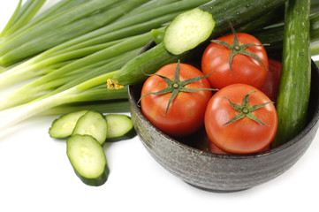Fototapeta na wymiar Bowl of fresh raw red tomatoes and slices cucumbers with onion