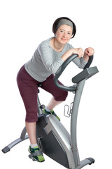 Woman, middle-aged on a stationary bike practicing for slimming.