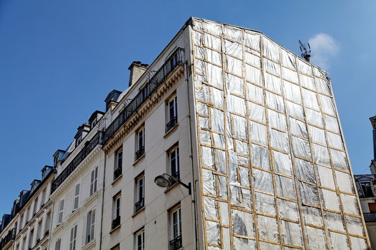 Immeuble avec façade bâchée.