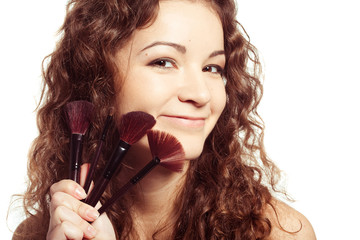Portrait of young happy smiling woman with make up tools